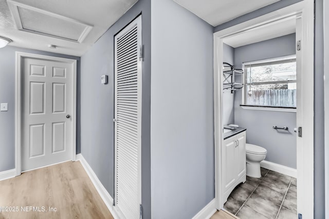 bathroom featuring baseboards, vanity, and toilet