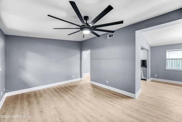 unfurnished room with visible vents, ceiling fan, baseboards, and wood finished floors