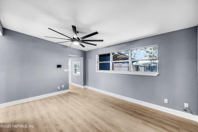 unfurnished room featuring ceiling fan, baseboards, and wood finished floors