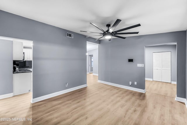 interior space with ceiling fan, baseboards, visible vents, and light wood-style floors