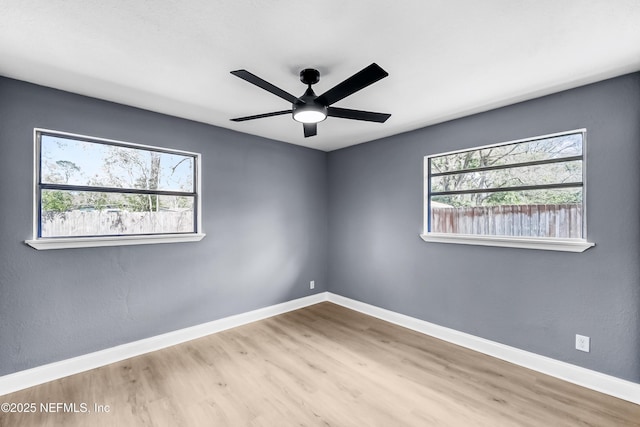 unfurnished room with a ceiling fan, baseboards, and wood finished floors