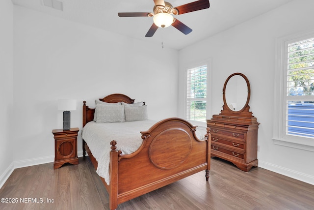 bedroom featuring visible vents, multiple windows, and wood finished floors