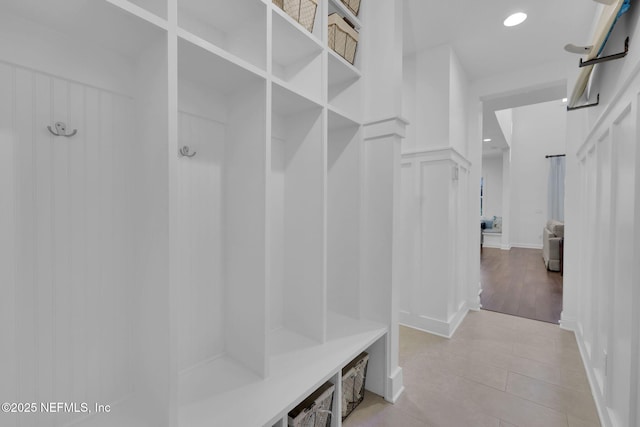 mudroom with a decorative wall and recessed lighting