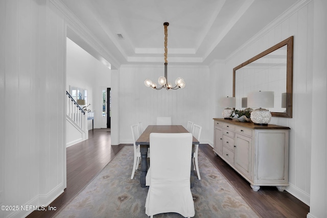 dining space with visible vents, a tray ceiling, dark wood finished floors, a chandelier, and stairs