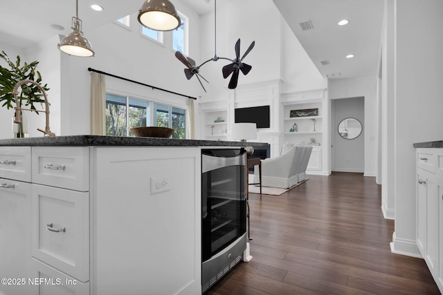 kitchen with wine cooler, visible vents, white cabinets, and a wealth of natural light