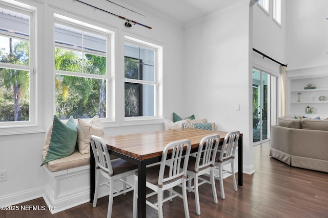 dining area featuring built in features, baseboards, wood finished floors, and ornamental molding