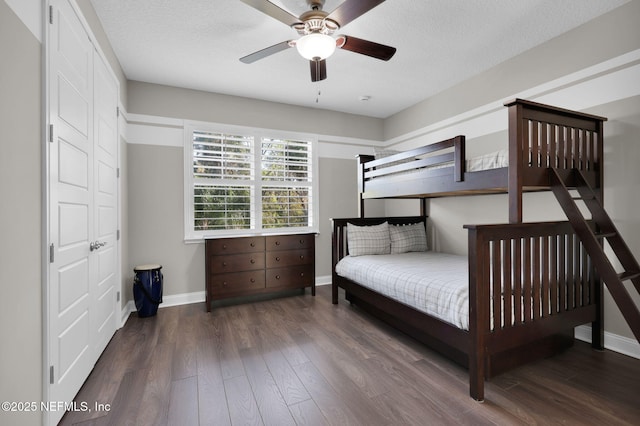 bedroom with a textured ceiling, baseboards, and wood finished floors