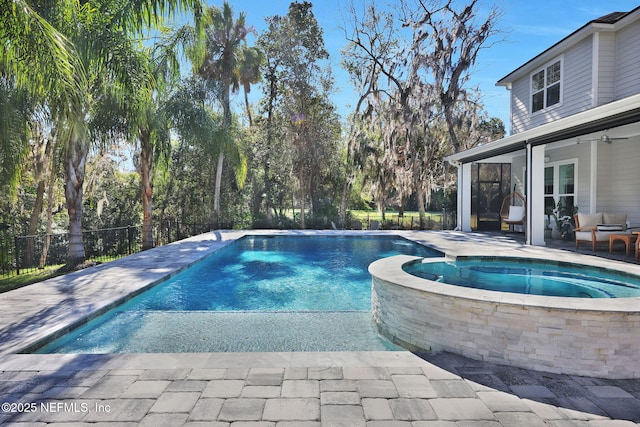 view of swimming pool featuring a patio, fence, and a pool with connected hot tub