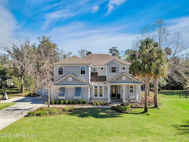 view of front of property with a porch, concrete driveway, a front yard, and fence