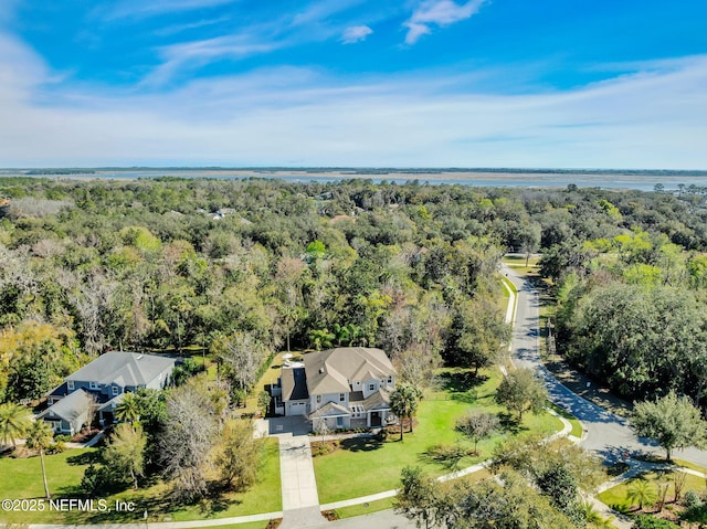 birds eye view of property with a water view and a wooded view