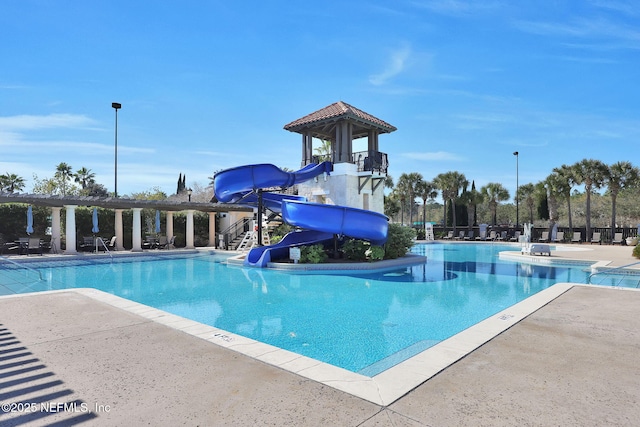 community pool featuring a patio area and a water slide