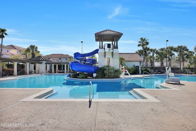 community pool with a water slide and a patio