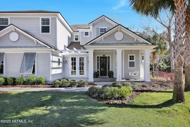 view of front of property featuring a front lawn, covered porch, and roof with shingles