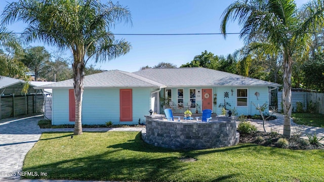 ranch-style home featuring decorative driveway, a front yard, and fence