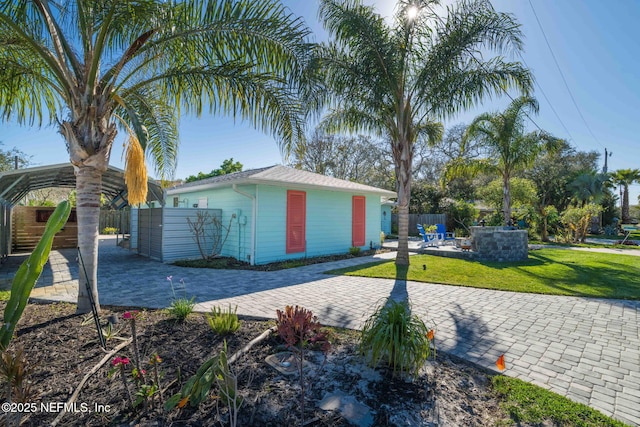 view of side of property with a yard, a patio, and fence