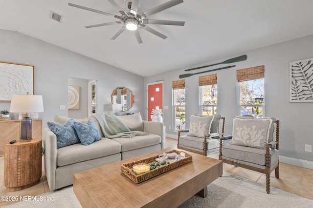 living area featuring baseboards, visible vents, a ceiling fan, lofted ceiling, and light tile patterned flooring