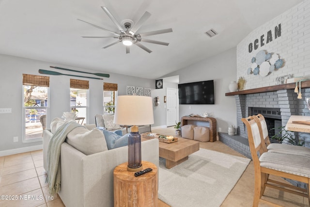 living area with lofted ceiling, a brick fireplace, visible vents, and light tile patterned floors