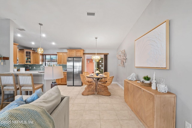 living area with baseboards, visible vents, an inviting chandelier, and light tile patterned floors