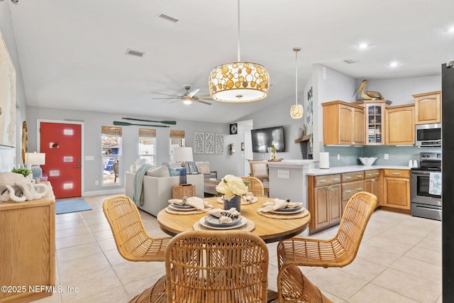 dining room featuring light tile patterned floors, ceiling fan, lofted ceiling, and visible vents