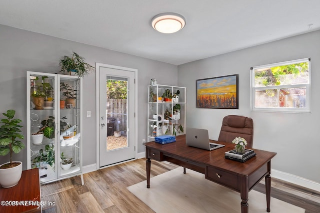 office space with light wood-type flooring and baseboards