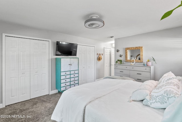 carpeted bedroom with visible vents and two closets