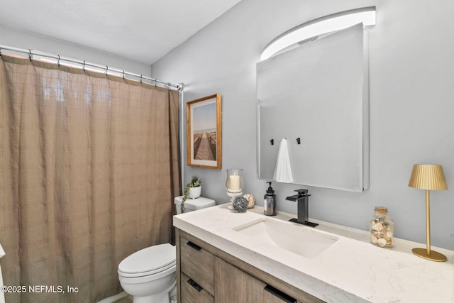 bathroom with curtained shower, vanity, and toilet