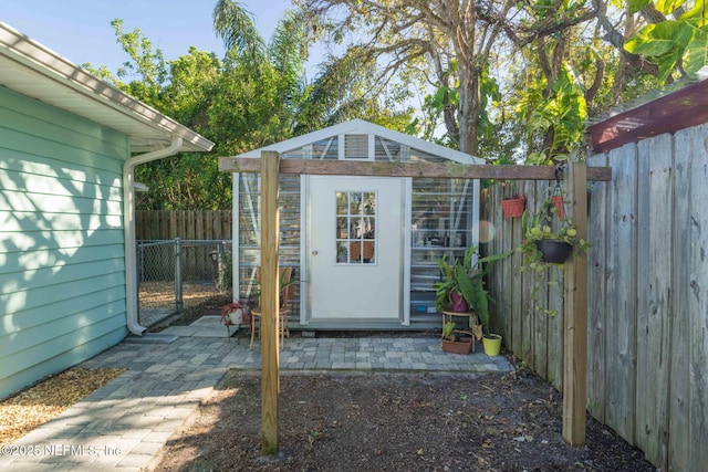 view of outdoor structure featuring a gate, fence, and an outdoor structure