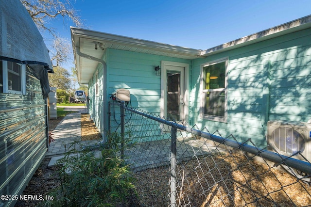 view of property exterior featuring ac unit and fence