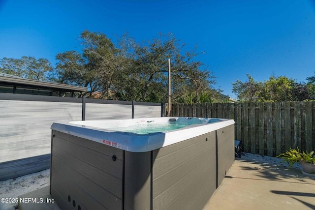 exterior space with a hot tub and a fenced backyard