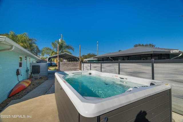 view of pool with fence, a hot tub, and a gazebo