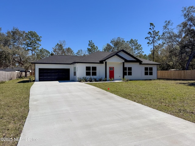 view of front facade with a garage, concrete driveway, a front yard, and fence