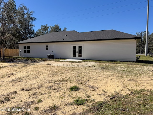 rear view of property featuring french doors, fence, and central air condition unit