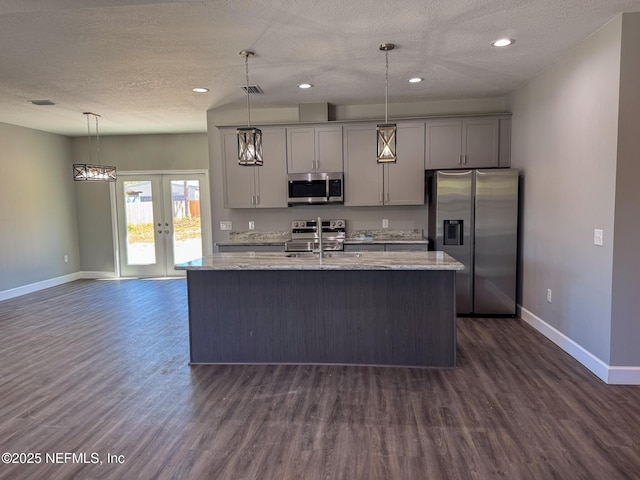 kitchen with french doors, stainless steel appliances, gray cabinetry, a kitchen island with sink, and a sink