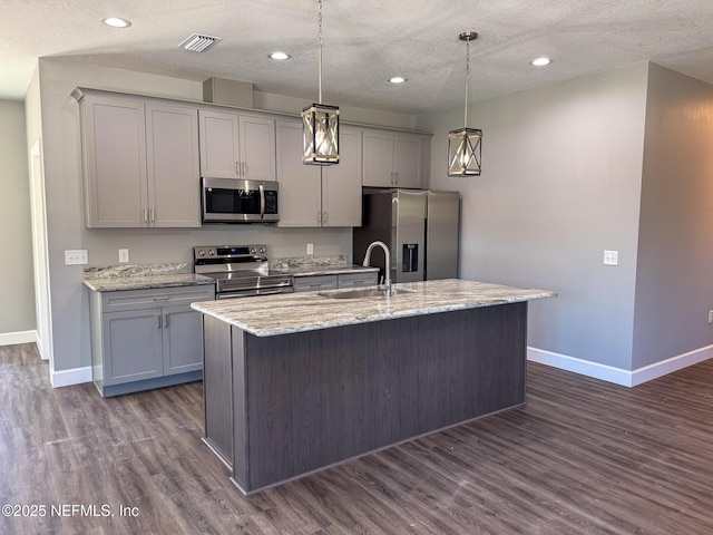 kitchen featuring stainless steel appliances, gray cabinets, a sink, and dark wood-style flooring