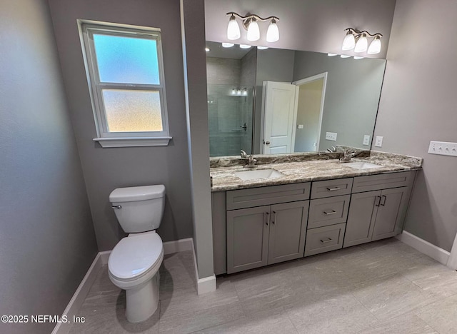 bathroom with toilet, a stall shower, baseboards, and a sink