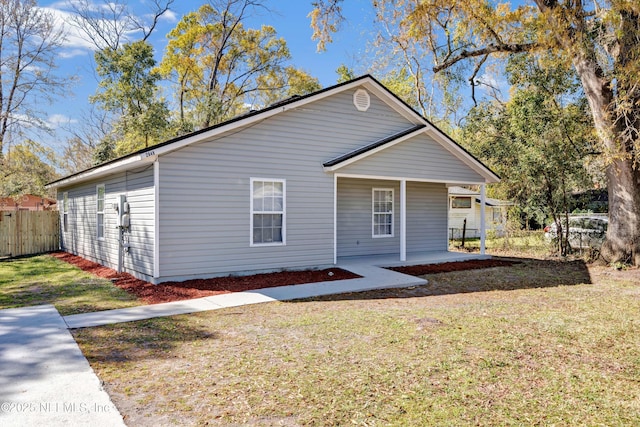 back of property featuring fence and a lawn