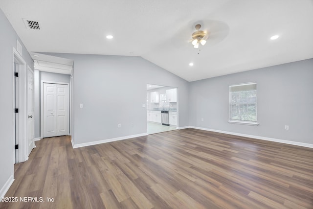 unfurnished living room with lofted ceiling, visible vents, ceiling fan, wood finished floors, and baseboards