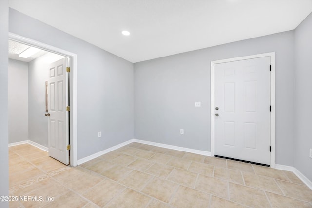 spare room featuring baseboards and light tile patterned floors