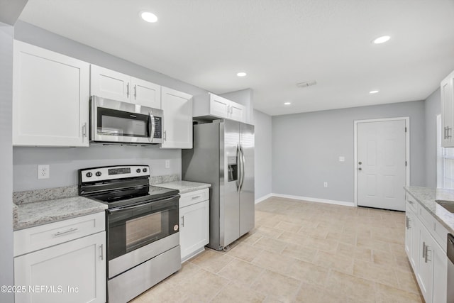 kitchen featuring appliances with stainless steel finishes, recessed lighting, white cabinetry, and light stone counters