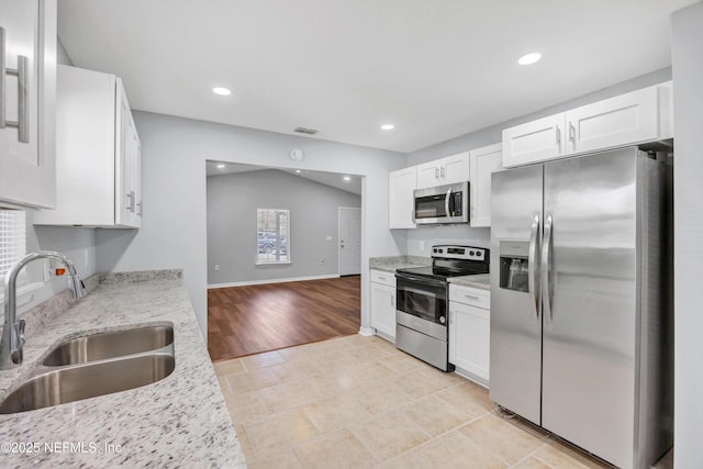 kitchen featuring stainless steel appliances, visible vents, a sink, and white cabinetry