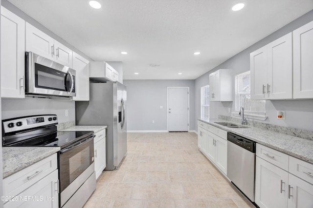 kitchen featuring recessed lighting, stainless steel appliances, a sink, white cabinetry, and baseboards