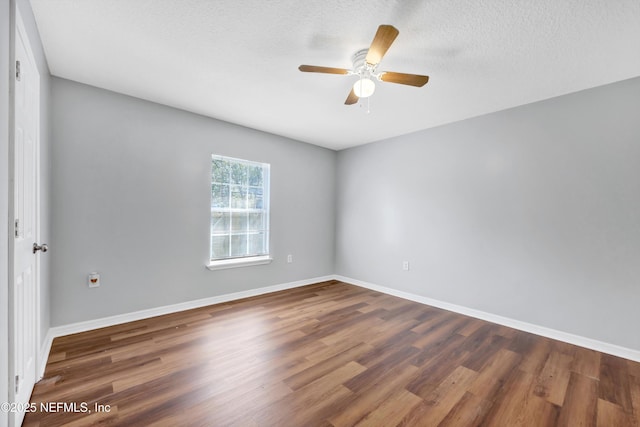 empty room featuring ceiling fan, a textured ceiling, baseboards, and wood finished floors