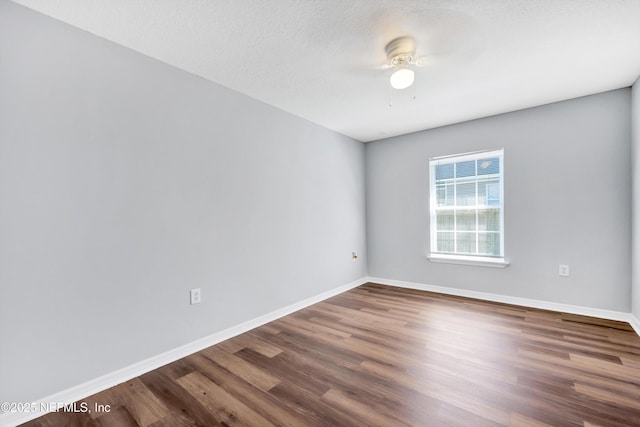 empty room featuring a ceiling fan, a textured ceiling, baseboards, and wood finished floors