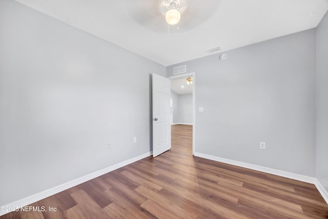 unfurnished room featuring visible vents, baseboards, and wood finished floors