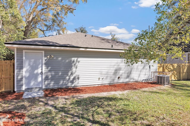 view of home's exterior featuring cooling unit, fence, and a lawn