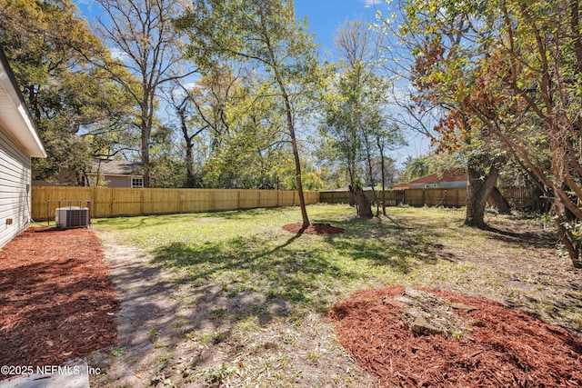 view of yard with a fenced backyard and central AC