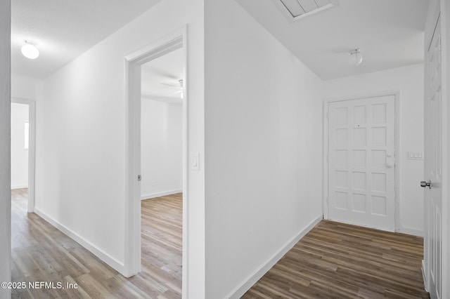 hallway featuring baseboards and wood finished floors