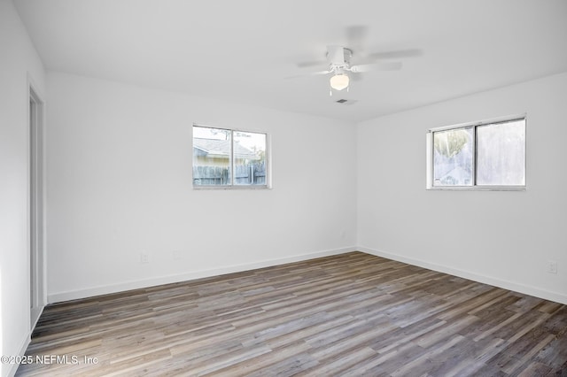 unfurnished room with visible vents, baseboards, and wood finished floors