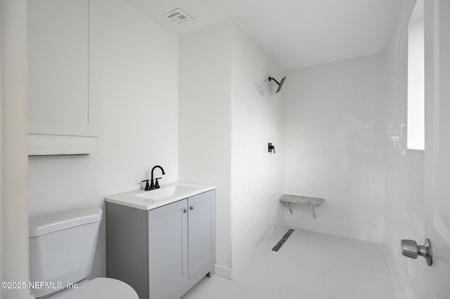 full bath featuring visible vents, toilet, vanity, and tiled shower