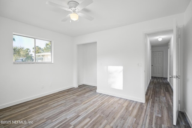 unfurnished room featuring baseboards, wood finished floors, and a ceiling fan